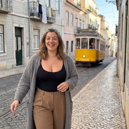 Body modelador preto usado como top com calças camel, numa rua de Alfama em Lisboa